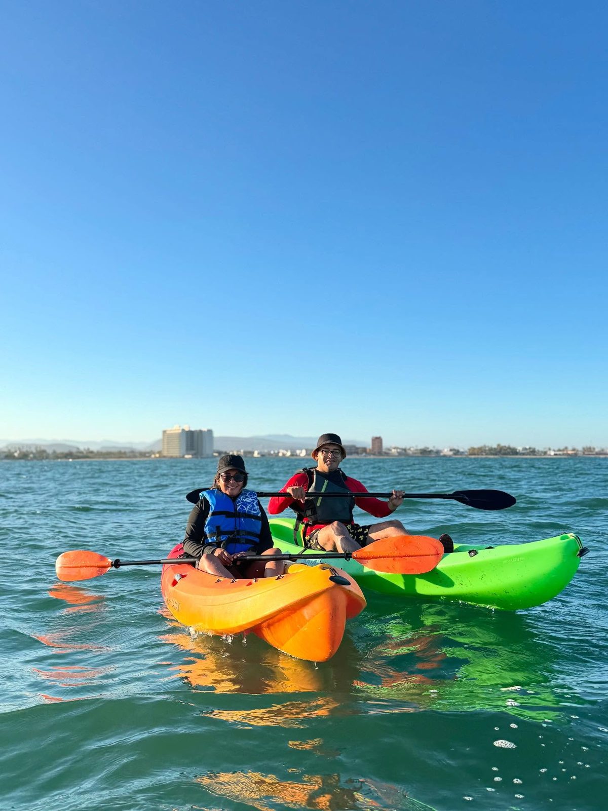 Grupo en kayaks de colores disfrutando en la bahía turquesa de La Paz
