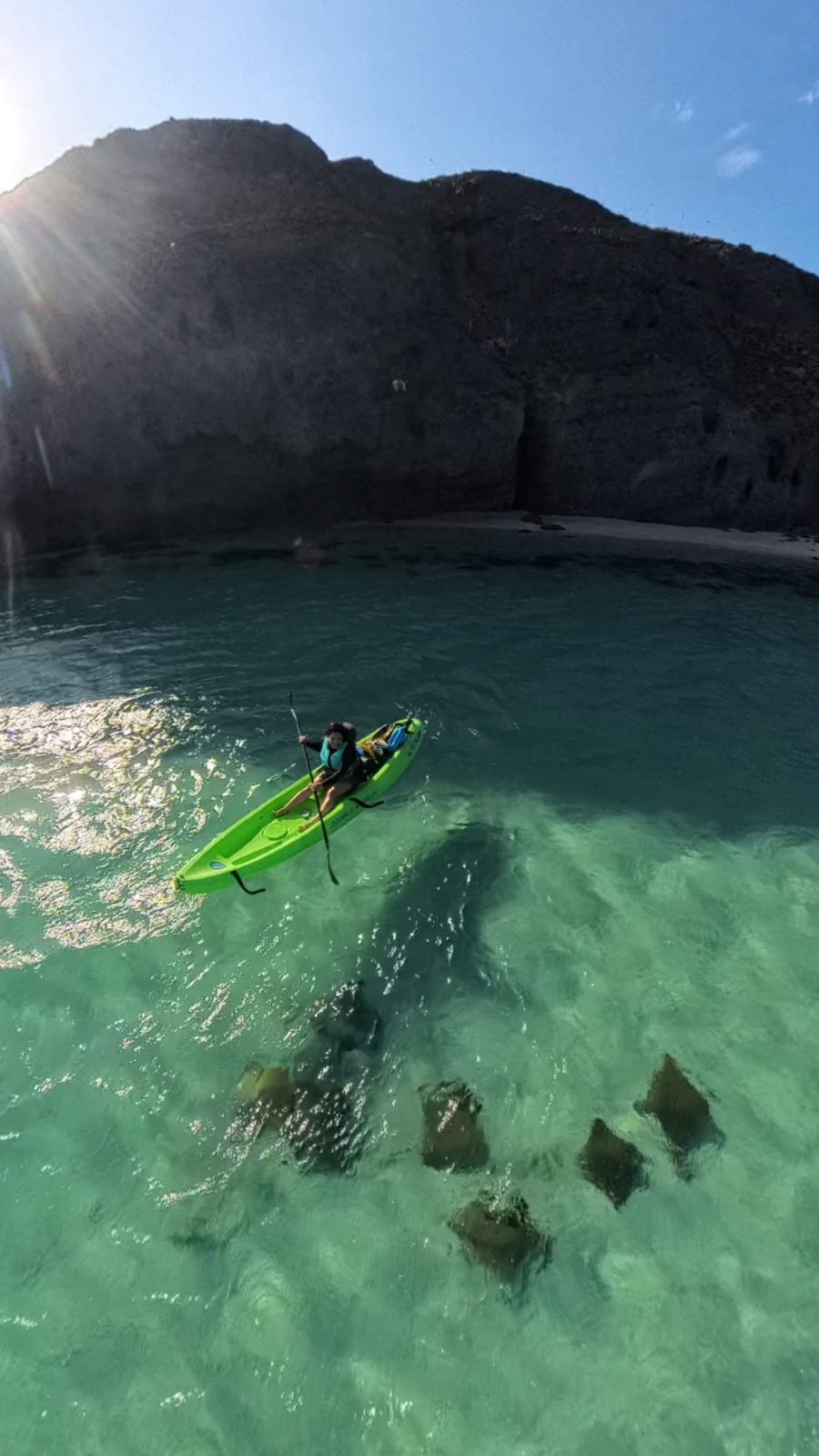 Kayak en la bahía de Tecolote con el sol sobre el cerro