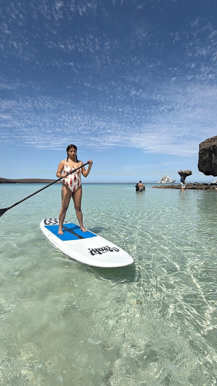 Paddleboarder cruzando el agua cristalina de Tecolote